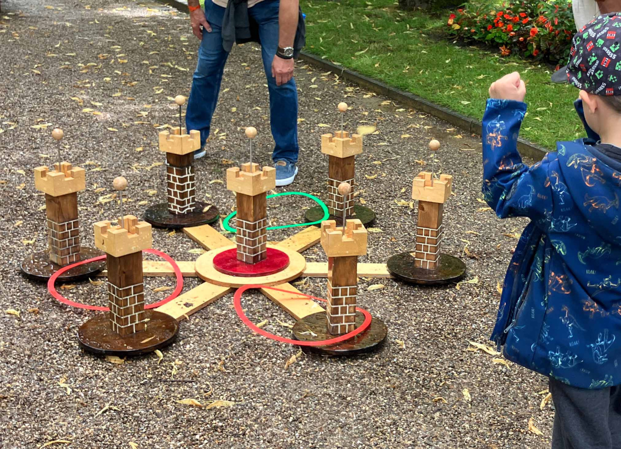 Kind spielt ein Holzspiel draußen