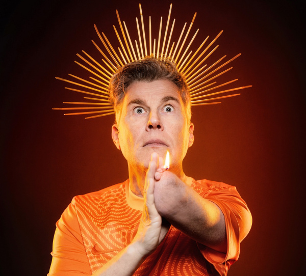 Martin Fromme mit Heiligenschein hinterm Kopf und Kerzenflamme aufem Arm