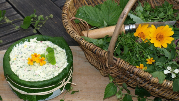 Kräuter im Korb, daneben verarbeitet zu Kräuterbutter