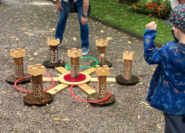 Kind spielt ein Holzspiel draußen