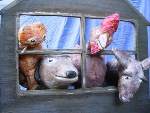 Vier tierische Handpuppen schauen durch ein Fenster