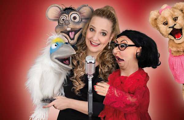 Sängerin mit vier verschiedenen Handpuppen um sich herum