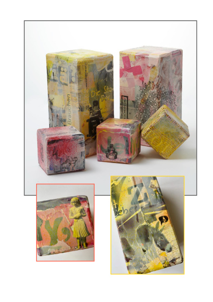 die Aufnahme zeigt verschieden große Boxen, die kunstvoll collagiert sind mit Farbe und Text