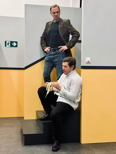 Zwei Schauspieler dikutieren auf einer Treppe.