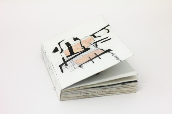 Ein hangefertigtes und mit abstrakt anmutenden Zeichnungen bebildertes Künstlerbuch auf grauem Grund