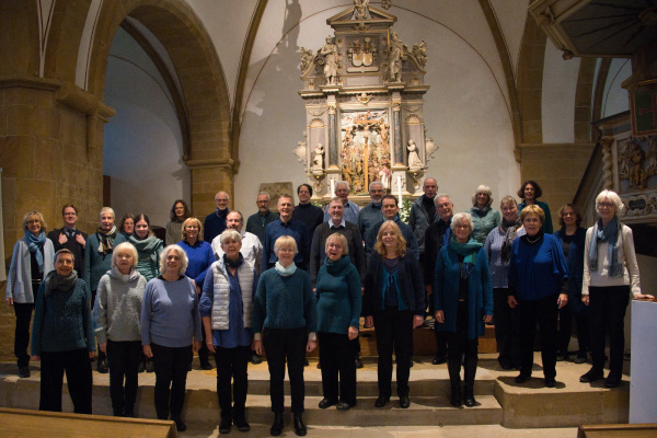 Chorfoto mit den Sängerinnen und Sängern des Chores Vocapella Bielefeld und ihrem Dirigenten