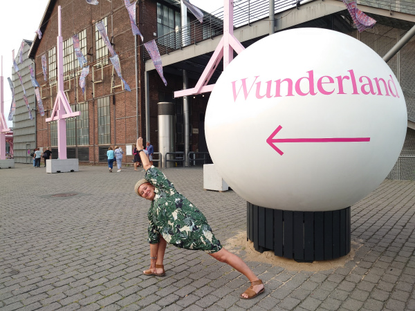 eine große weisse Kugel mit der Aufschrift Wunderland, davor eine Frau in einer Yogapose
