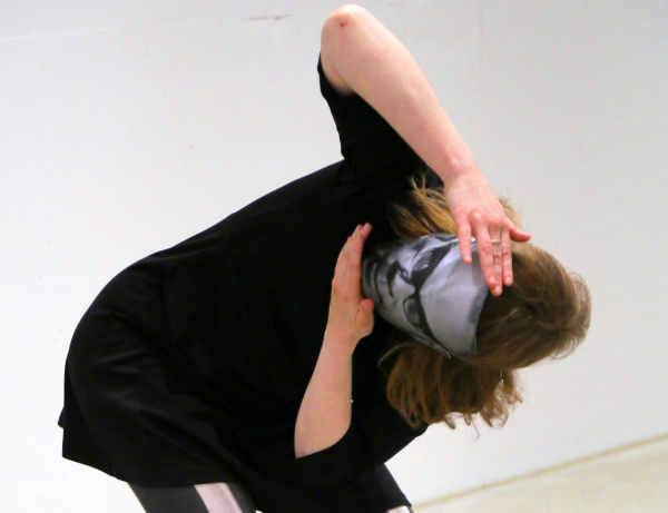 eine Person mit einer Maske beugt und bewegt sich