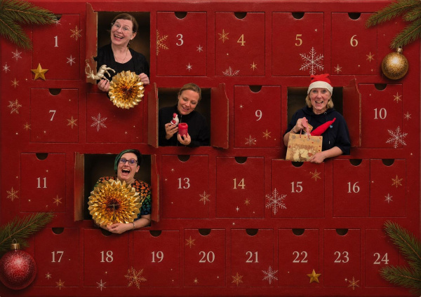 Vier Personen, die aus Türchen eines Adventskalenders schauen.